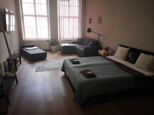 sala de estar con 2 camas y sofá en Palace - Belvárosi Apartman Eger, en Eger