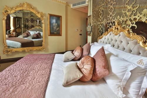 a hotel room with a large bed and a painting on the wall at Daru Sultan Hotels Galata in Istanbul