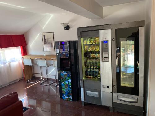 dos máquinas expendedoras en una tienda con una bebida en Hotel Malpensafiera en Bernate Ticino