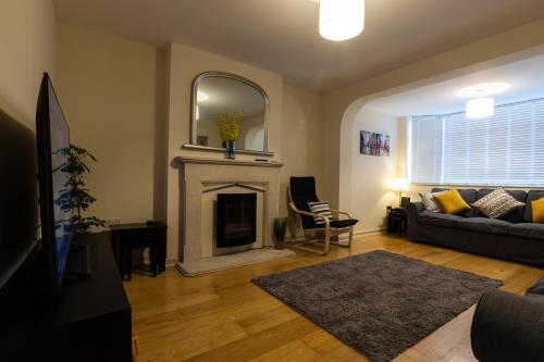 a living room with a couch and a fireplace at Merewood House in Oxford