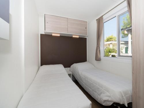 a bedroom with two beds and a window at Club del Sole Stork Family Collection in Giulianova