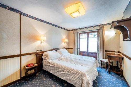 a hotel room with a bed and a window at Hotel Petit Prince in Antagnod