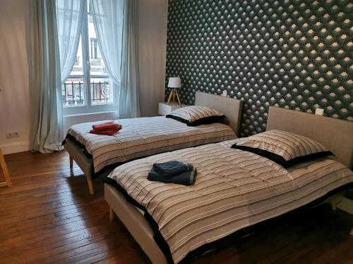 deux lits côte à côte dans une chambre dans l'établissement Chez Camille, à Reims