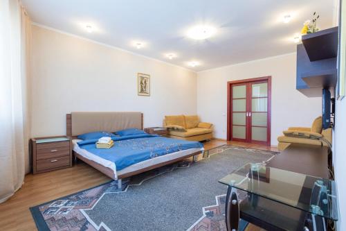 a bedroom with a bed and a couch and a table at Apartments on Darnitsa in Kyiv