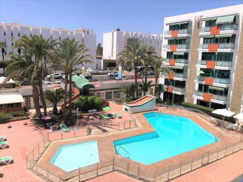 an overhead view of a swimming pool with palm trees and buildings at FM Beach Home - Winter Sun Apartment with Pool & Terrace in Playa del Ingles