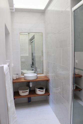 Baño blanco con lavabo y espejo en Paul Sabatier-T1-Vue sur Jardin-Luxe-wifi-fi-vélo, en Castelnaudary