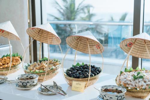 a table with baskets of different types of food at Phương Bắc Luxury Hotel in Dong Hoi
