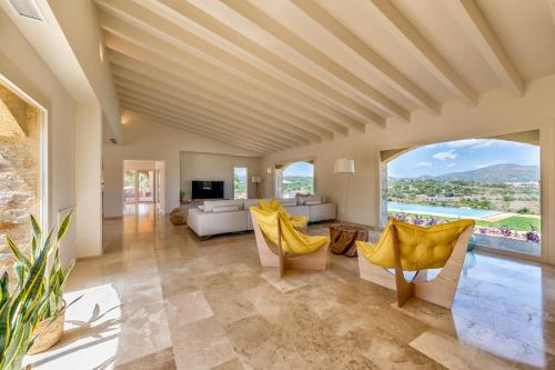 a living room with yellow chairs and a couch at Es Lligats Agroturismo - Adults Only in Sant Llorenç des Cardassar