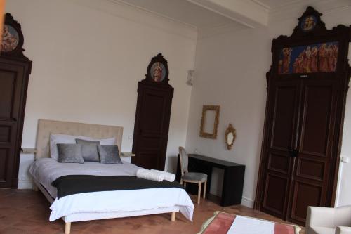 1 dormitorio con 1 cama y reloj en la pared en CHIC ANDREOSSY-COSY-AUTHENTIQUE-WI-Fi-Vélo, en Castelnaudary