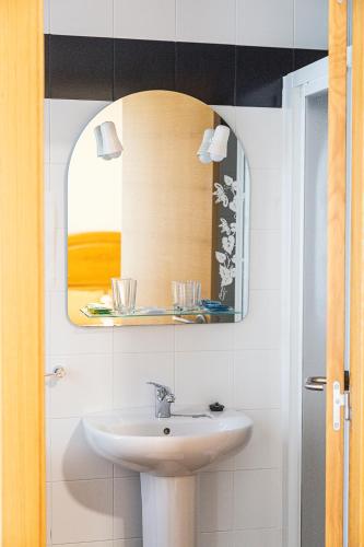 a bathroom with a sink and a mirror at Hotel Flor de Sal in Porto do Son