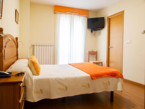 Un dormitorio con una cama con una manta naranja. en Hotel Ancora da Ria 1* Superior, en Porto do Son