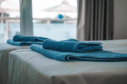 three blue towels sitting on top of a bed at Kaos Hotel Apartments in Ayia Napa