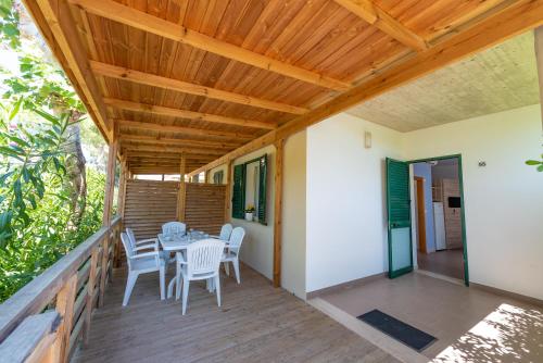 a patio with a table and chairs on a deck at Club del Sole Stork Family Collection in Giulianova