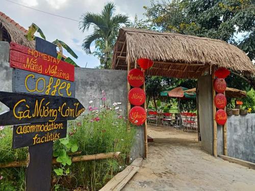 a sign in front of a building with a restaurant at Homestay Nang Nghieng in Kon Tum