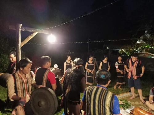 un grupo de personas de pie alrededor de la noche en Homestay Nang Nghieng, en Kon Tum