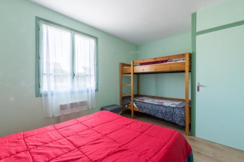 ein Schlafzimmer mit Etagenbett und Fenster in der Unterkunft La Petite Isle - Maison et jardin - plage à 200 m in Barneville-Carteret