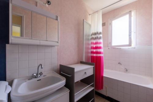 ein Badezimmer mit Waschbecken, Badewanne und Fenster in der Unterkunft La Petite Isle - Maison et jardin - plage à 200 m in Barneville-Carteret