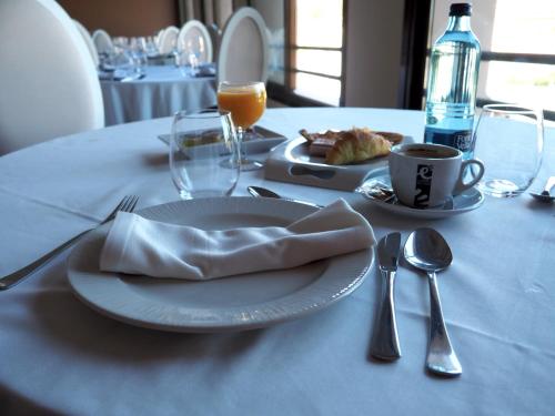 una mesa con un plato de comida y una taza de café en Hotel ELE Acueducto en Segovia