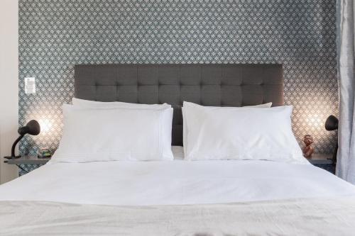 a bed with white sheets and pillows in a bedroom at Alimama Spaces: The Manson's Kikuyu in Sandown