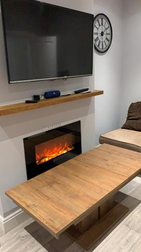 a living room with a fireplace with a tv above it at Breeze on Southend in Essex in Southend-on-Sea