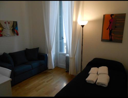 a living room with a bed and a blue couch at Aldebaran in Milan