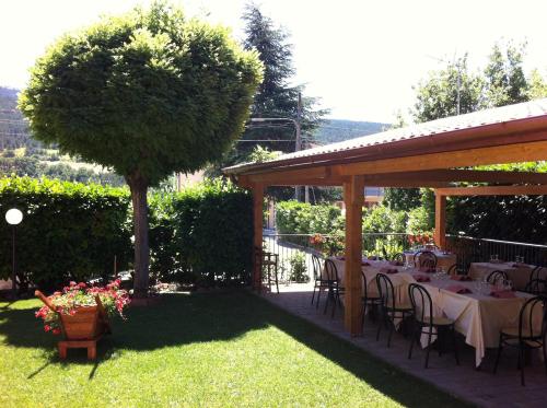 a garden with tables and chairs under a pavilion at Hotel Giampy in Assergi