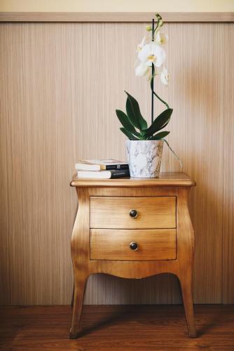 a table with a flower in a vase on it at Hotel Corallo in La Spezia