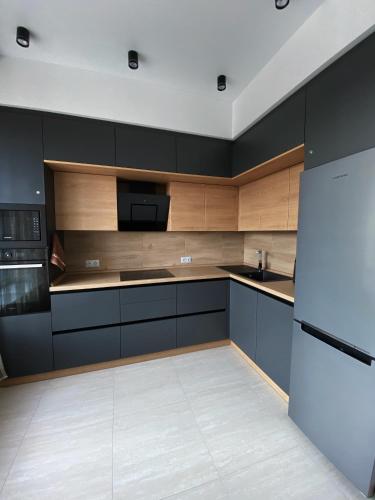 uma cozinha com armários pretos e um aparelho branco em VIP Apartment Rovno & Новобудова ЖК Театральний Центр em Rivne