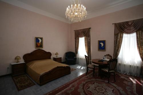 a bedroom with a bed and a table and a chandelier at Giuseppe Hotel in Kazan