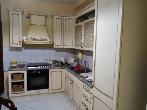 una cucina con armadi bianchi e piano cottura di CASA 92100 appartamento in centro ad Agrigento. a Agrigento
