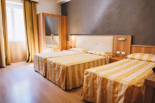 a hotel room with two beds and a window at Hotel Corallo in La Spezia