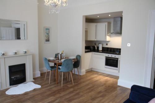 a kitchen and dining room with a table and chairs at Mostyn Villa in Llandudno