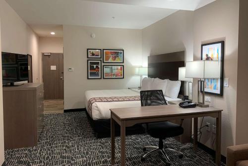 a hotel room with a bed and a desk at La Quinta Inn & Suites by Wyndham - Red Oak TX IH-35E in Red Oak