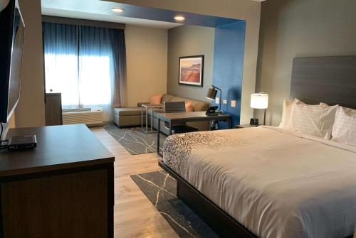 a hotel room with a bed and a living room at La Quinta Inn & Suites by Wyndham Holbrook Petrified Forest in Holbrook