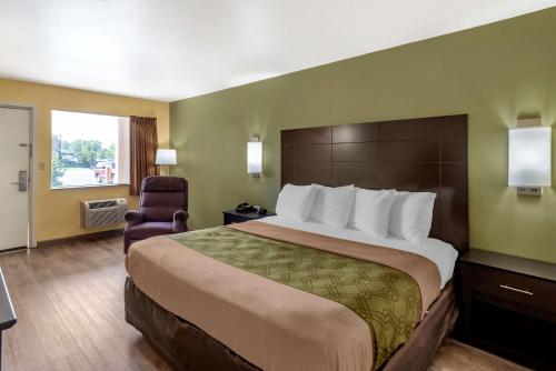 una habitación de hotel con una cama grande y una silla en Econo Lodge Easton Route 50, en Easton