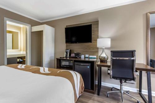 a hotel room with a bed and a desk and a television at Quality Inn & Suites in Pawleys Island