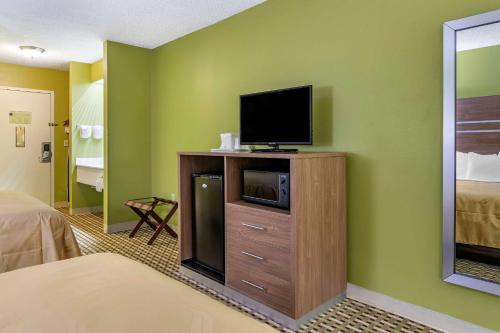a room with a television on a cabinet with a bed at Quality Inn Brunswick in Brunswick