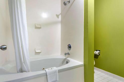 a bathroom with a white tub and a green wall at Quality Inn Brunswick in Brunswick