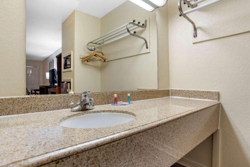 een badkamermeubel met een wastafel en een spiegel bij Econo Lodge Pearl - Jackson in Pearl