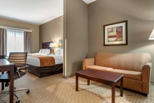 Habitación de hotel con cama, sofá y mesa en Comfort Suites Biloxi/Ocean Springs, en Biloxi