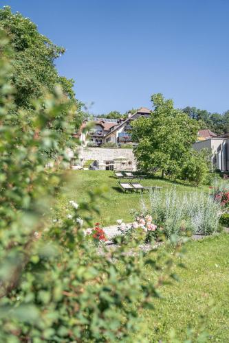 a park with a bench and flowers in the grass at Hotel Bemelmans-Post in Collalbo