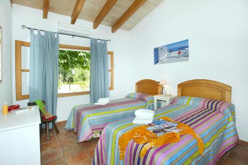 a bedroom with two beds and a window at Villa BURGUES in Alcudia