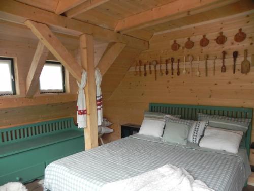 a bedroom with a bed in a log cabin at IEDERA Casa de Familii 2 in Pianu de Sus