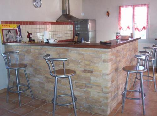 um bar com quatro bancos de bar numa cozinha em Gîte Etchegoyhen em Lacarry-Arhan-Charritte-de-Haut