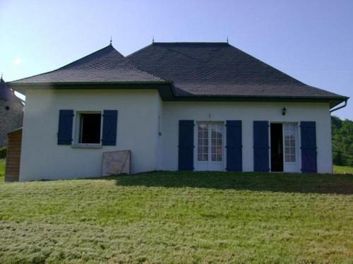 a white house with a black roof and a yard at Gîte Etchegoyhen in Lacarry-Arhan-Charritte-de-Haut