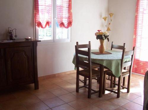 a dining room table with chairs and a vase of flowers at Gîte Etchegoyhen in Lacarry-Arhan-Charritte-de-Haut