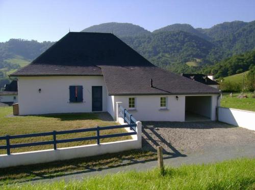 una casa bianca con un tetto nero e una recinzione di Gîte Etchegoyhen a Lacarry-Arhan-Charritte-de-Haut