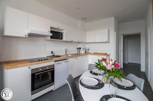 une cuisine avec une table avec un vase de fleurs dessus dans l'établissement Gîte de Granit Bleu, à Besse-et-Saint-Anastaise