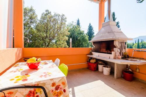 uma varanda com uma mesa e um forno de pizza em Apartments Donita em Slano