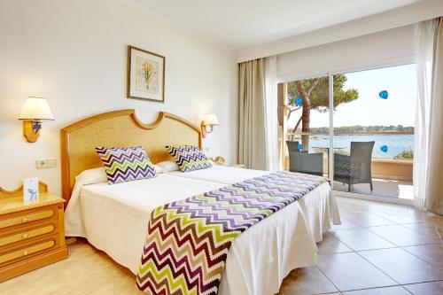 a bedroom with a bed and a view of the ocean at Grupotel Santa Eulària & Spa - Adults Only in Santa Eularia des Riu